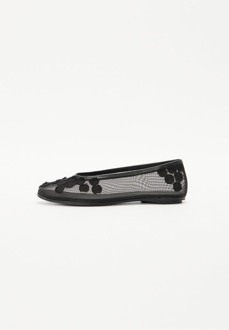 Ballerine en mesh noir avec un bout arrondi, ornée d'accents floraux texturés et d'une semelle noire lisse. Design léger et respirant.