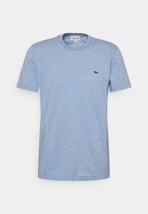 T-shirt in cotone azzurro chiaro con colletto rotondo, maniche corte e logo di coccodrillo ricamato verde sul lato sinistro del petto.