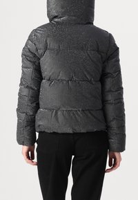 Svart puffjacka med en skimrande finish, med horisontella kviltade sektioner och huva. Designen är stoppad för isolering.