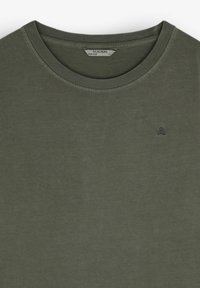 Oliven grøn crew neck T-shirt lavet af blød bomuld, med et lille, broderet kraniumlogo på venstre bryst. Glat tekstur, afslappet design.