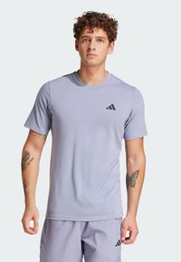 Lichtpaarse sportt-shirt gemaakt van zacht materiaal. Voorzien van korte mouwen, een ronde halslijn en een klein zwart logo op de linkerborst.
