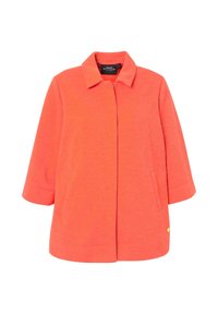 Korálově oranžová bunda z texturované látky, s límečkem, rukávy 3/4 a bočními kapsami. Výrazný zlatý akcent na dolní straně.