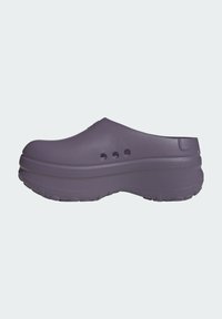 Zuecos de goma morados con punta redondeada, parte superior texturizada y tres agujeros de ventilación en el costado. Suela gruesa y acolchada para mayor soporte.