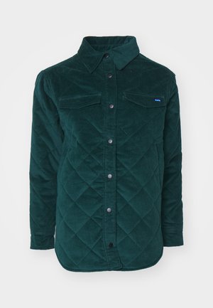 Quilted dark green corduroy shirt jacket with a button-up front, two chest pockets, and a classic collar. Textured fabric with a diamond pattern.
