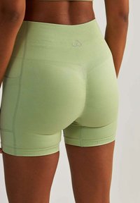 Sportowe szorty z wysokim stanem w jasnym zielonym kolorze. Posiadają teksturę prążkowaną, dopasowany fason oraz małe, jasne logo z tyłu.