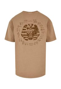 Bruine katoenen t-shirt met een farao-afbeelding en hiërogliefenontwerpen op de achterkant. Korte mouwen en een ronde hals.