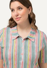 Camicia a maniche corte con colletto, caratterizzata da righe verticali in verde, rosa e giallo. Realizzata in tessuto morbido con chiusura a bottoni davanti.