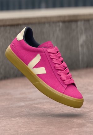 Sneaker in suede rosa con dettagli e lacci color crema, punta tonda e suola in gomma gialla flessibile. Presenta un evidente logo 'V' sui lati.
