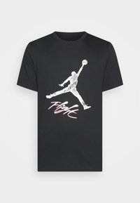 Černé tričko s krátkým rukávem s bílou siluetou basketbalisty skákajícího a slovem "Flight" ve stylizovaných písmenech níže.