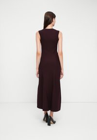 Burgundy ärmlös klänning med en figursydd bodice och utsvängd kjol, gjord av textilerat tyg, med en subtil korskärningsdetalj och en slät fåll.