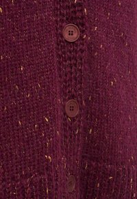 Cardigan lavorato a maglia color bordeaux con brillanti dorati, tessuto testurizzato e dettagli con bottoni marroni lungo la parte frontale.