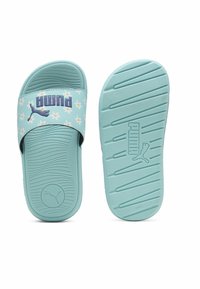 Šviesiai mėlynos slydimo šlepetės su gėlėtą dirželiu ir "PUMA" logotipu. Tekstūruota guminė pado danga suteikia sukibimą ir patogumą.