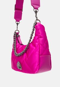 Kwiatowy różowy nylonowy torebka z pikowaniem, z srebrnym łańcuchem i dekoracyjnym srebrnym emblem na przedzie, o zbudowanej, zakrzywionej formie.