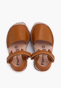 Sandali per bambini in pelle marrone con cinturini regolabili, punta chiusa, fodera in pelle e suole in gomma nera. Logo stampato all'interno.