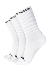 Calcetines de algodón blancos en un paquete de tres, con textura acanalada, diseño de longitud por el tobillo y letras de logo negras en el puño y el dedo del pie.