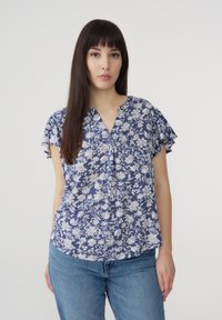 Blusa floreale blu con motivi bianchi, maniche corte a volant e scollatura a V. Realizzata in tessuto leggero, presenta una vestibilità morbida.