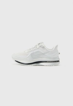 Witte Nike Air Zoom hardloopschoen met mesh bovenwerk, grijze Swoosh-logo en zwarte gevoerde zool op een lichtgrijze achtergrond.
