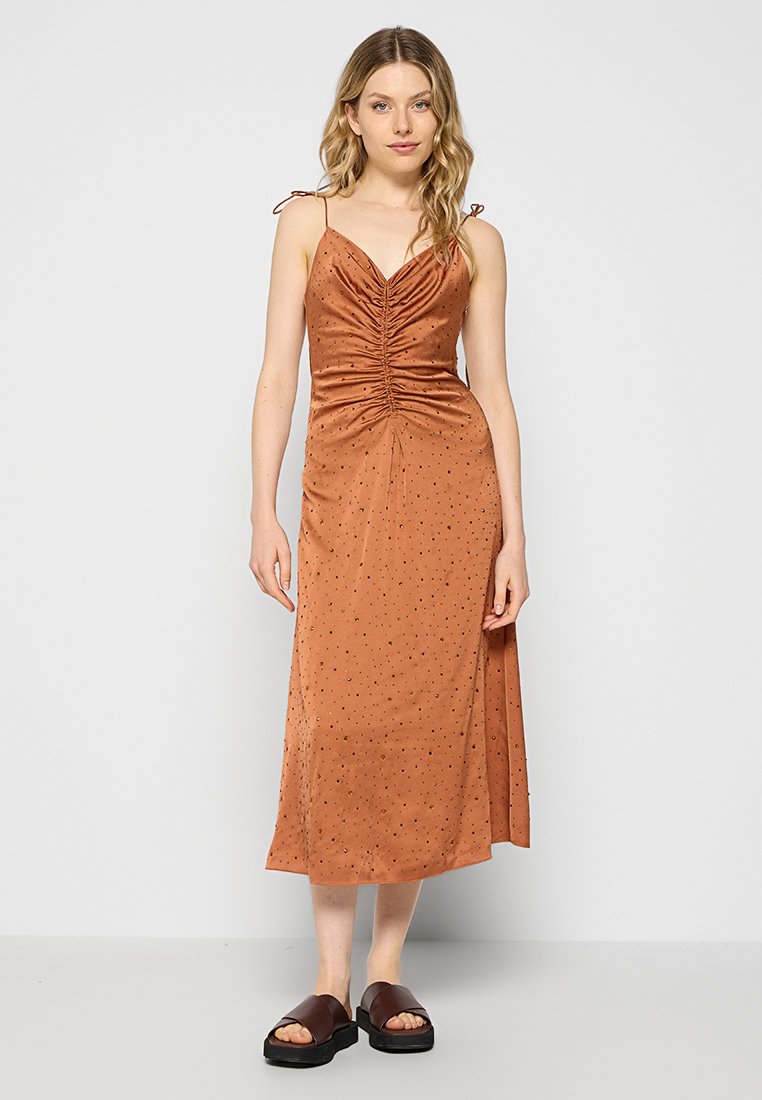 Vestido de satén color óxido con un cuerpo ajustado y detalles fruncidos, que presenta tirantes ajustables y adornos negros dispersos.