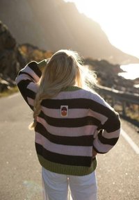 Sweter w paski w kolorach różowym, czarnym i zielonym, z teksturalnym wzorem dzianiny i metką na plecach. Sweter ma luźny krój.