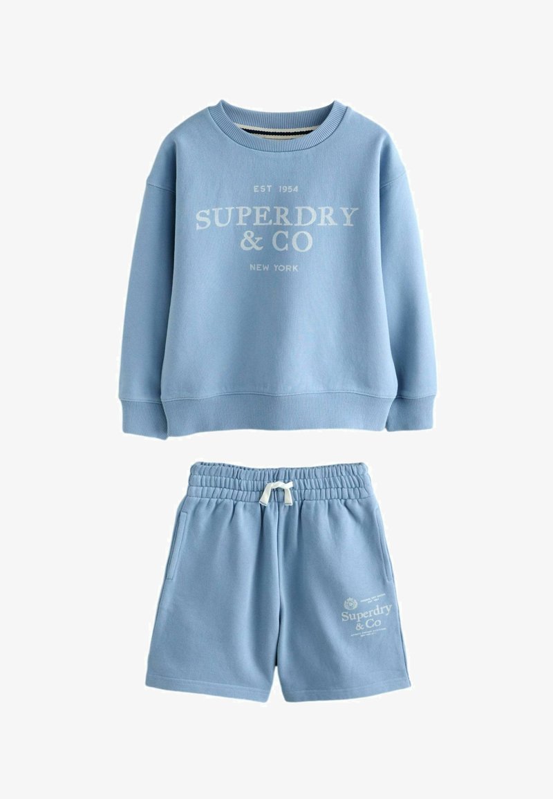 Svetlomodrá mikina s textom "Superdry & Co New York" a zodpovedajúce kraťasy s elastickým pásom a šnúrkou na stiahnutie, oboje z jemnej látky.