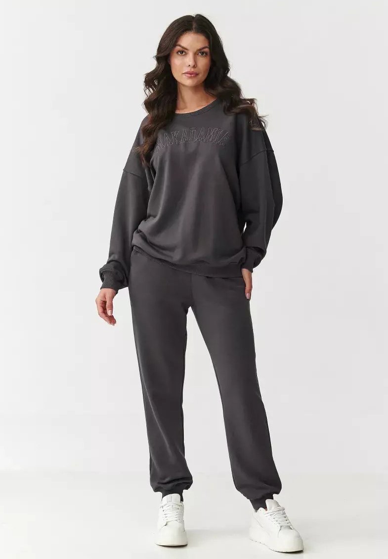 Ciemnoszary dres bawełniany z luźną bluzą z ribbowanymi mankietami oraz dopasowanymi spodniami dresowymi z elastycznymi ściągaczami u kostek i kieszeniami.