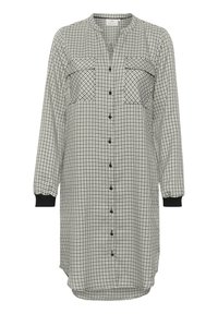 Abito a camicia realizzato in tessuto leggero. Motivo a scacchi bianco e nero con due tasche sul petto, maniche lunghe e polsini neri.