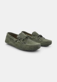 Grüne Wildleder-Mokassins mit einem Slip-On-Design, ausgestattet mit Front-Schnürung, dekorativen Nähten und strukturierten Gummisohlen.