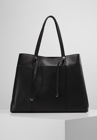 Czarna skórzana torba tote o teksturowanej powierzchni, z dwoma długimi uchwytami, metalowymi akcentami i otwartą górą. Minimalistyczny design z przestronnym wnętrzem.