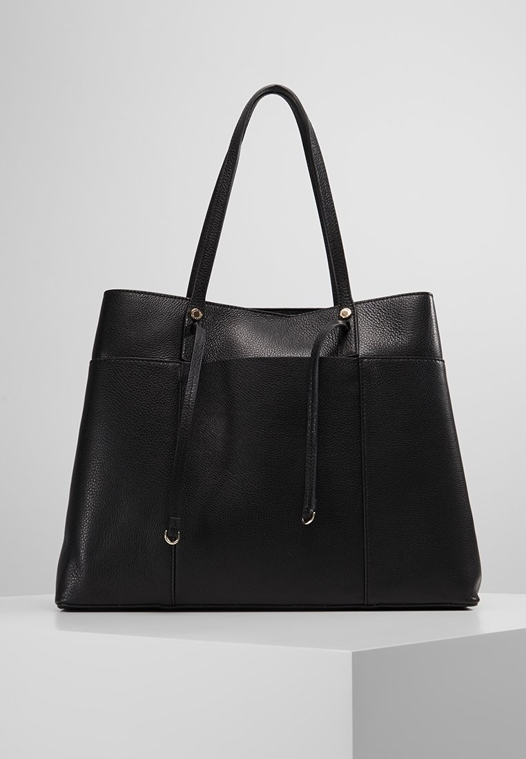 Czarna skórzana torba tote o teksturowanej powierzchni, z dwoma długimi uchwytami, metalowymi akcentami i otwartą górą. Minimalistyczny design z przestronnym wnętrzem.