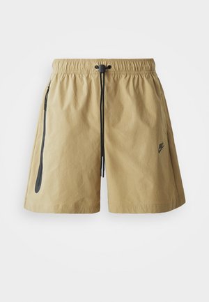 Shorts couleur marron clair en tissu léger, avec une taille élastique à cordon de serrage, des poches latérales et un détail logo subtil.