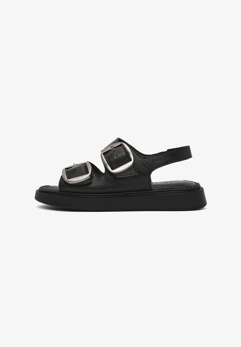 Black leather sandals with two wide adjustable buckles, open design, thick black sole, and stitched accents along the edges.