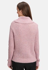 Rosa gestrickter Pullover mit weitem Kragen, geripptem Muster und langen Ärmeln. Abgerundet mit einem leicht verkürzten Saum und lockerer Passform.