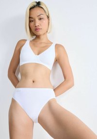 White cotton bra with a V-neckline and matching high-waisted briefs, featuring soft texture and minimalistic design.