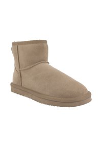 Stivaletto in suede cammello con punta arrotondata, interno morbido e suola piatta in gomma. Presenta una cucitura e una hardware minimale.