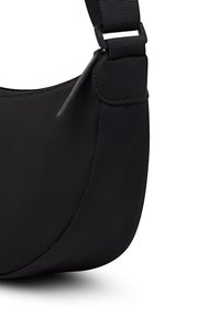 Bolso bandolera negro con correa ajustable, cierre de cremallera y textura de tela lisa sobre fondo blanco.