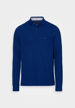 Navyblauw poloshirt met lange mouwen, een kraag met knopen en een klein Tommy Hilfiger-logo op de linkerborst.