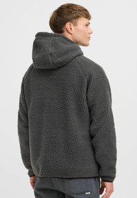 Grijze fleece hoodie met een gestructureerd oppervlak, een ontspannen pasvorm en een verstelbare capuchon. Het heeft een kangoeroezak en geribbelde manchetten.