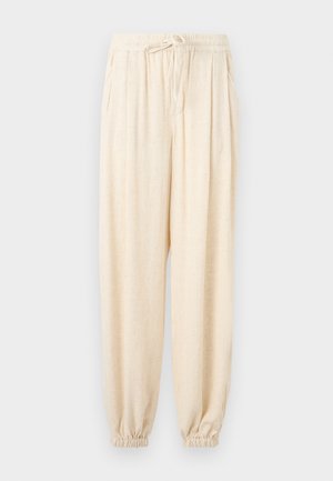 Kreminiai laisvo kirpimo kelnės su elastine juosmens juosta, raišteliais, šoninėmis kišenėmis ir elastinėmis rankogaliais ties kulkšnimis.