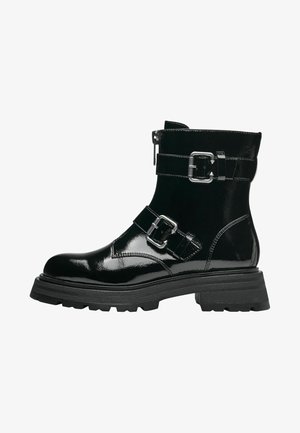 Black patent leather ankle boot with two buckle straps, a side zipper, chunky rubber sole, and smooth glossy texture.