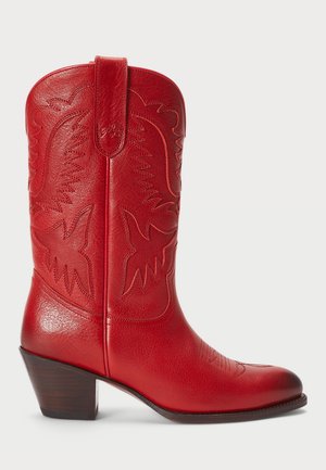 Bota vaquera de cuero rojo con punta afilada, costuras decorativas y tacón de madera apilada. Presenta una pestaña para facilitar su colocación.