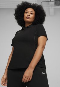 Zwarte poloshirt met korte mouwen, voorzien van een kraag en subtiele grijze accenten, gecombineerd met bijpassende zwarte onderkleding. Logo op het shirt.