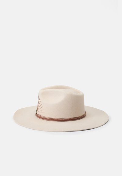 Brede crème kleurige vilten hoed met een ronde kroon, voorzien van een bruine leren band en decoratieve stikselaccenten.