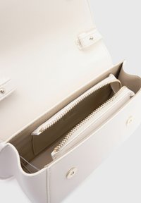 Witte neplederen schoudertas met twee ritscompartimenten, goudkleurige hardware en druksluiting. Stevige textuur, minimalistisch design.