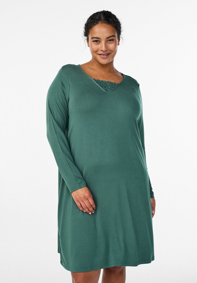 Zielona sukienka z długim rękawem, dekoltem w kształcie litery V i koronkowymi zdobieniami przy szyi. Wykonana z miękkiego materiału o luźnym kroju.
