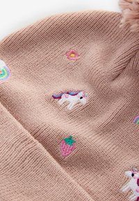 Stickad rosa mössa med broderade enhörningar, jordgubbar, blommor och regnbågar; mjuk textur med en pom-pom på toppen.