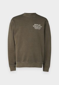 Sudadera verde oliva hecha de una mezcla de algodón, con cuello redondo, mangas largas y un gráfico de texto blanco en la parte izquierda del pecho.