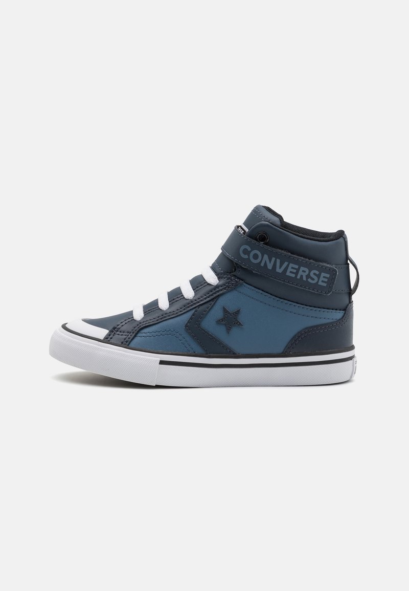 Hoge Converse-schoenen in marineblauw en lichtblauw synthetisch materiaal. Voorzien van witte veters, een band met "CONVERSE"-opdruk en een sterrenlogo.