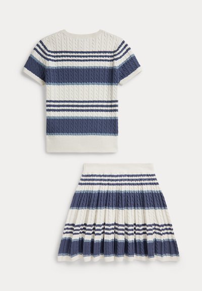 Σετ με πουλόβερ με πλεκτό σχέδιο και κοντά μανίκια και φούστα με πτυχώσεις, με οριζόντιες ρίγες σε μπλε, ναυτικό μπλε και λευκό σε λευκό φόντο.