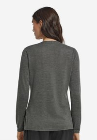 Graues Langarmshirt mit Rundhalsausschnitt, glatter Textur, seitlichen Schlitzen am Saum und gerippten Bündchen. Keine sichtbaren Muster oder Beschläge.