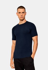 T-shirt a maniche corte blu navy realizzato in cotone morbido, con scollatura rotonda e vestibilità slim, caratterizzato da un branding minimale sul petto.